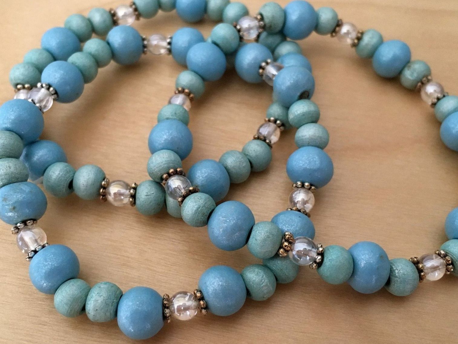 Tre blå pärlhalsband med silvriga detaljer